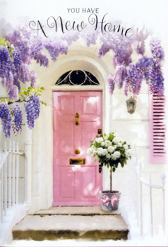 The photograph captures a serene front doorway in Norbiton, styled with the refined, romantic touch of an experienced local florist. A panelled front door painted in a delicate, powder-pink shade stands at the centre, its velvety matte finish softening the late-afternoon light that seems to bathe the scene. The door is framed by pale, whitewashed walls and a gently toned shutter, creating a calm, neutral backdrop that allows every floral detail to stand out. Above, a generous canopy of wisteria stretches across the entryway, sending down long strands of blossoms in shades of lavender and lilac. These hanging clusters create a natural arch, their petals forming airy curtains that partially veil the top of the door and cast lacy, shifting shadows across the step. You can almost imagine the faint perfume of the wisteria mingling with the scent of fresh paint and warm stone, much like the floral notes that drift through Norbiton's back gardens on a spring afternoon. On the doorstep, a grey metal bucket has been turned into a chic container, overflowing with white and cream roses arranged in artful layers. The roses themselves are plush and full, with velvety petals that spiral tightly at the centre before relaxing outward, giving a sense of luxury and tenderness. Sprigs of fresh greenery and muted, eucalyptus-like foliage peek out between the blooms, adding structure, depth, and a soft contrast of colour. A silky ribbon in a pale blush hue is wrapped around the bucket and tied into an understated bow, its tails trailing elegantly down the side. The overall impression is of a warm, understated celebration-a floral greeting waiting at the door of a new home in Norbiton, perfect for congratulating someone on their move and filling their threshold with a sense of welcome and hope.