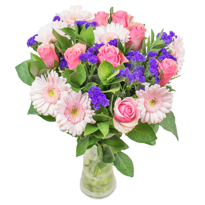 This striking bouquet features an elegant assortment of approximately 7 to 9 pink roses and 5 to 7 pale pink gerbera daisies, arranged by a florist near Norbiton's bustling centre. The roses, with their tightly curled petals and exquisite gradient from blush to rose, evoke imagery of classic English gardens in full bloom, while the gerberas stand out for their large, daisy-like faces with near-white centres-each one brightening the composition like the gentle morning light over Norbiton's suburban landscape. Throughout, vivid purple statice or limonium clusters are tastefully distributed, imparting bold textural contrast and a splash of deeper colour to the display, reminiscent of the vibrant markets along London Road. Anchoring the bouquet, lush, glossy green foliage frames the blooms and provides a vibrant sense of abundance, calling to mind the verdant expanses of Fairfield Recreation Ground. Presented in a pristine glass vase, where the cut stems and crystal-clear water are visible, the arrangement radiates a crisp, contemporary elegance. Available for same-day delivery across Norbiton through Flower Delivery Norbiton, this selection makes an ideal gift for occasions such as birthdays, anniversaries, or even a special gesture for a dear friend, conveying happiness, admiration, and the welcoming spirit of the local community.